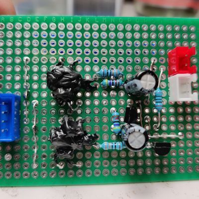 prototype-style circuit board with resistors, capacitors, and strange components covered in black acrylic